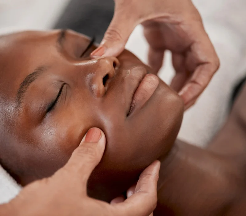 A woman receiving a facial in a bright, tranquil setting.