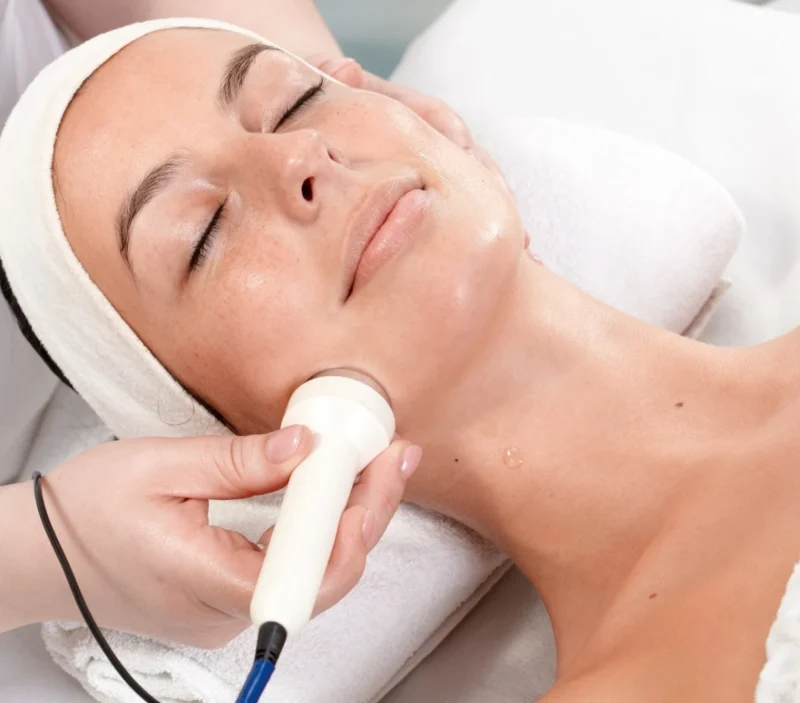 A woman receiving a facial with an ultrasonic cleanser.